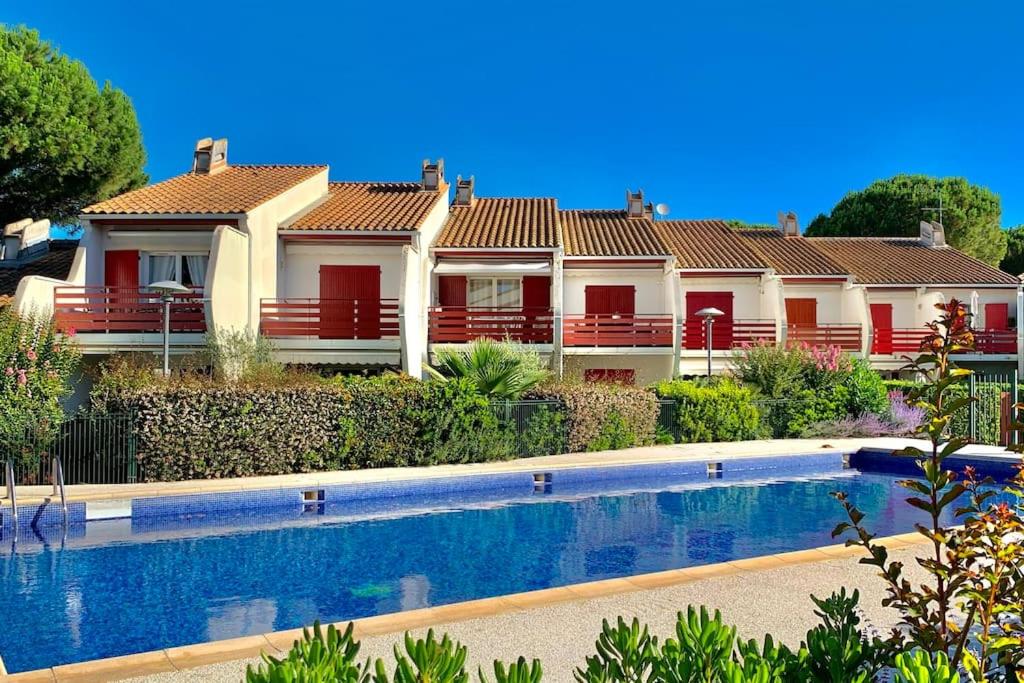 une maison avec une piscine devant dans l'établissement Duplex vue sur le Golf et piscine, à La Grande Motte
