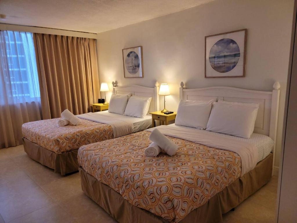 マイアミビーチにあるEstudios para 4 personas en la playa de Sunny Isles Beachのベッドが2つと窓があるホテルの部屋