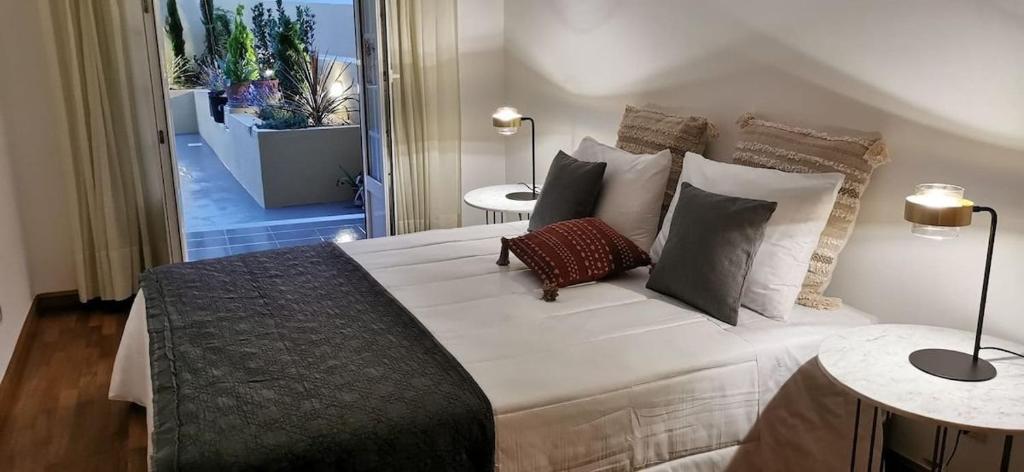 a bedroom with a large white bed with pillows at Casa Santa Maria - Tomar in Tomar