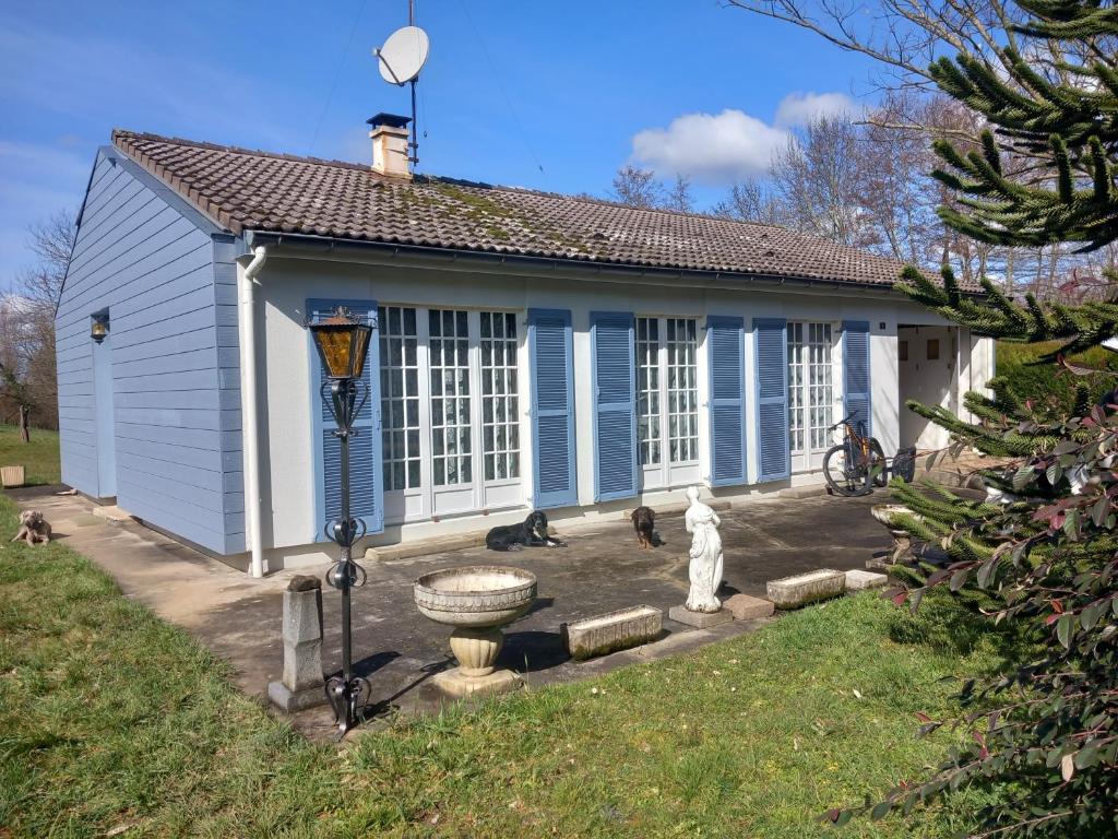 uma casa azul com gatos sentados do lado de fora em La maison des amoureux de ballades dans le Jura 