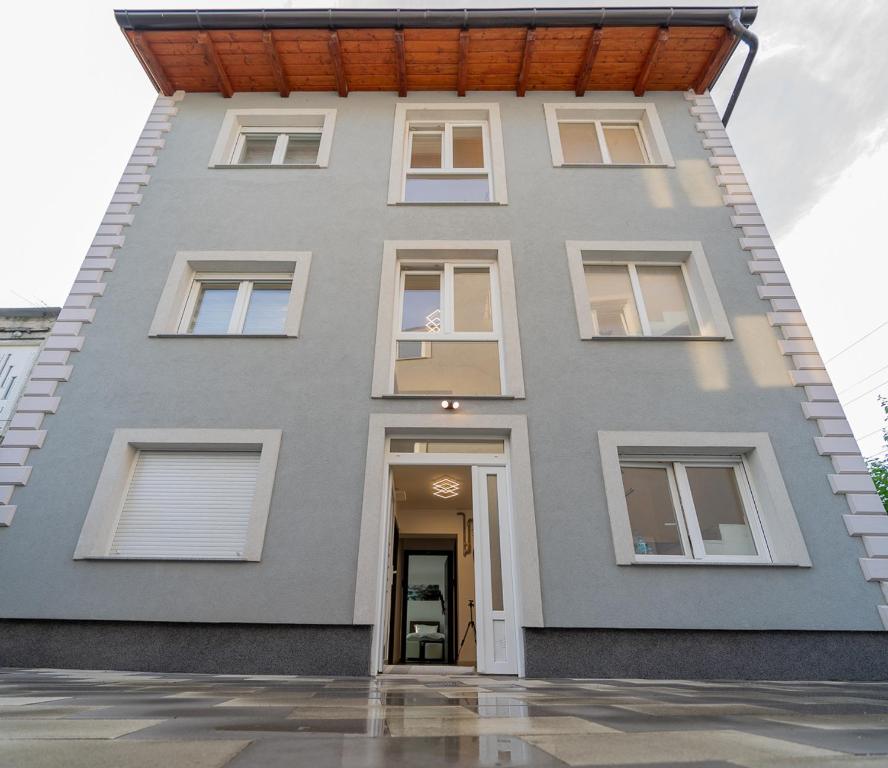 a gray house with a wooden roof at Arena Rooms Zagreb in Zagreb