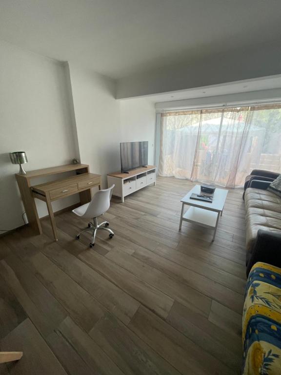 un salon avec un canapé et un bureau dans l'établissement Superbe 3 pièces épurée de 65 m2, refait à Neuf, dans residence calme, climatisé, place de parking privée, à 800 m de la plage, à Antibes