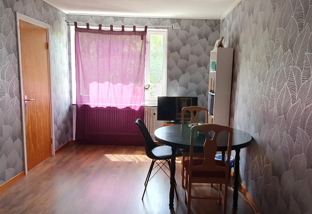 uma sala de jantar com uma mesa e uma janela cor-de-rosa em Apartment in Södertälje Stockholm em Södertälje