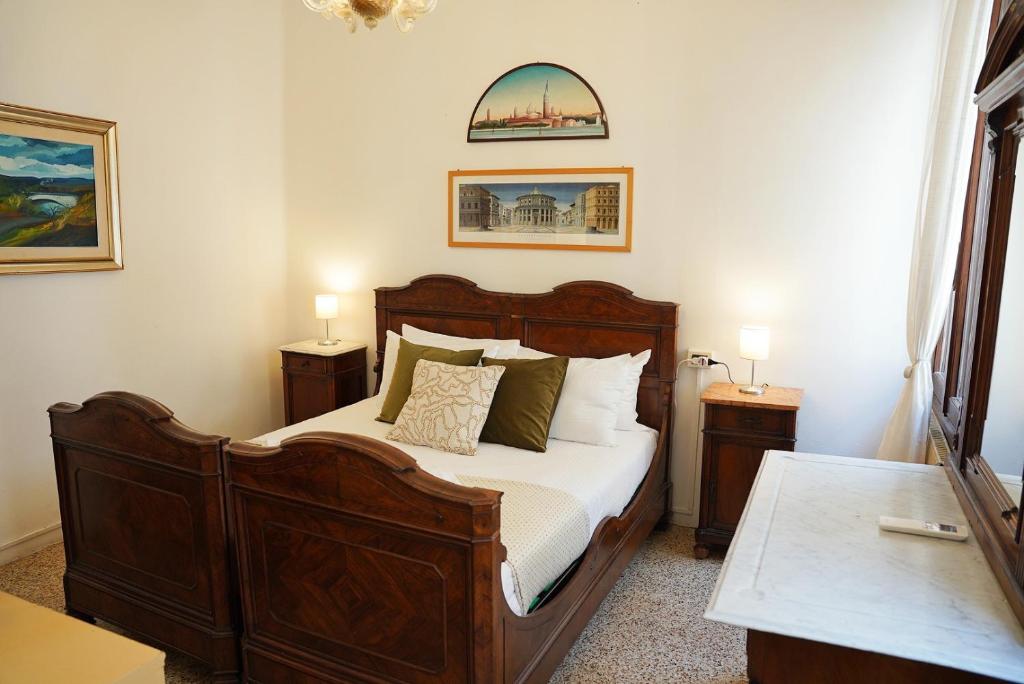 1 dormitorio con 1 cama de madera y 2 mesitas de noche en Ca' Alle Gondolette, en Venecia