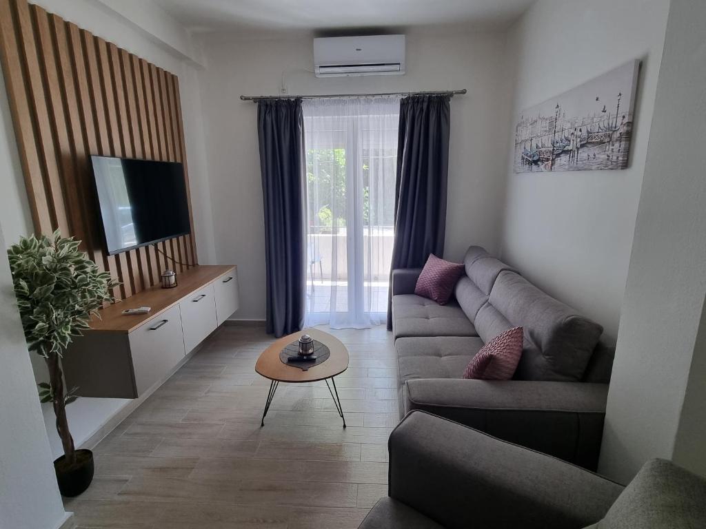 een woonkamer met een bank en een tafel bij Apartment Ninas in Dobrota