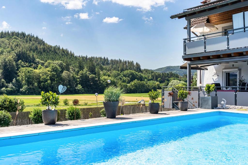 a villa with a swimming pool in front of a house at Ferienwohnung Geisbergblick in Seelbach