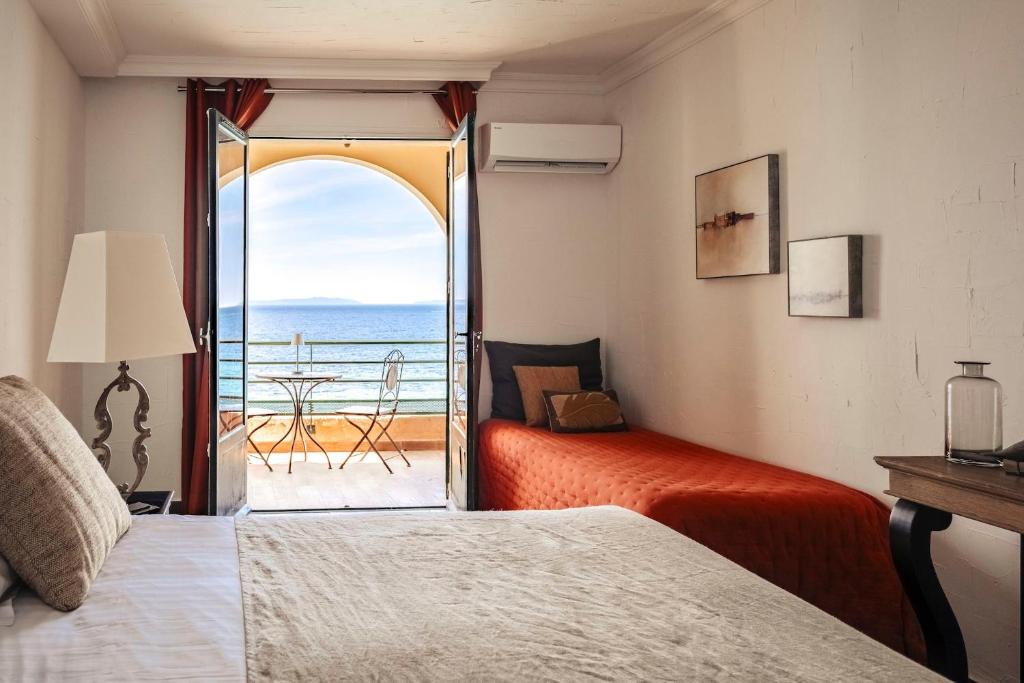 a bedroom with two beds and a view of the ocean at Surplage Hotel Cavalière in Le Lavandou