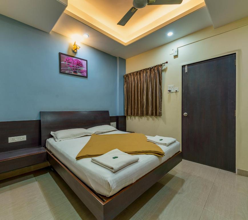 Schlafzimmer mit einem Bett und einem Deckenventilator in der Unterkunft Hotel RadhaKrishna-Couple Friendly in Kolhapur