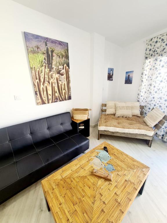 a living room with a black couch and a table at Vita Ideale in Arguineguín