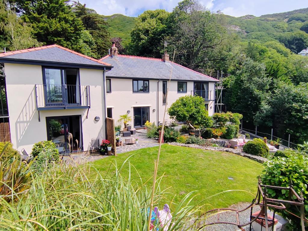 a white house with a garden in front of it at Bryn Mynach Annex in Barmouth