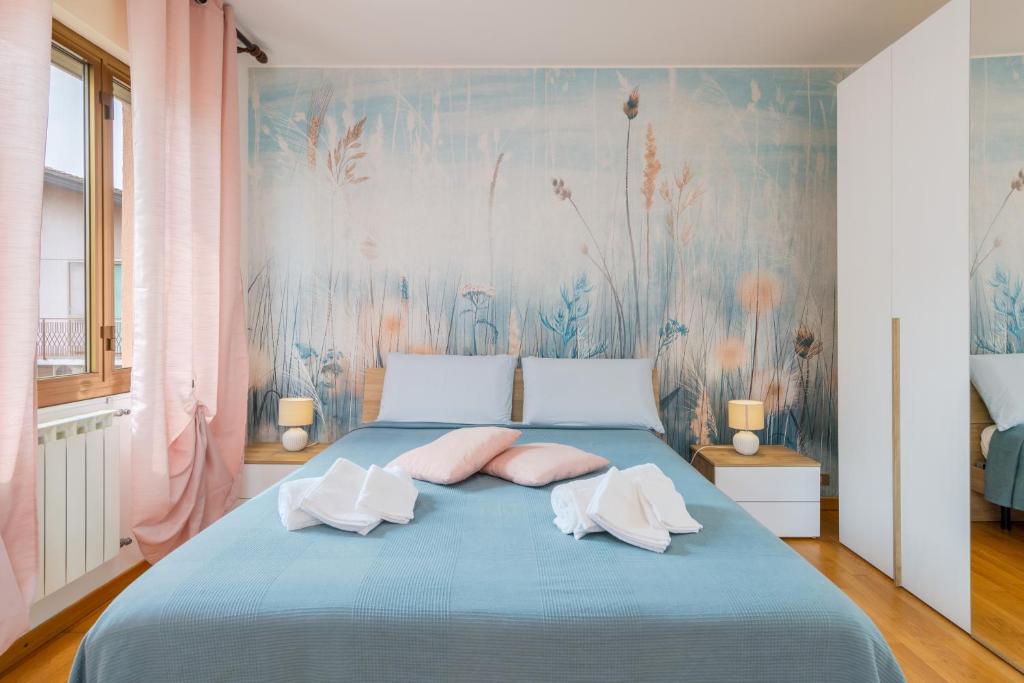 - une chambre avec un lit bleu et des oreillers roses dans l'établissement MarcoPoloAirport-3 Camere da letto-Wifi-Netflix-15' da Venezia, à Tessera