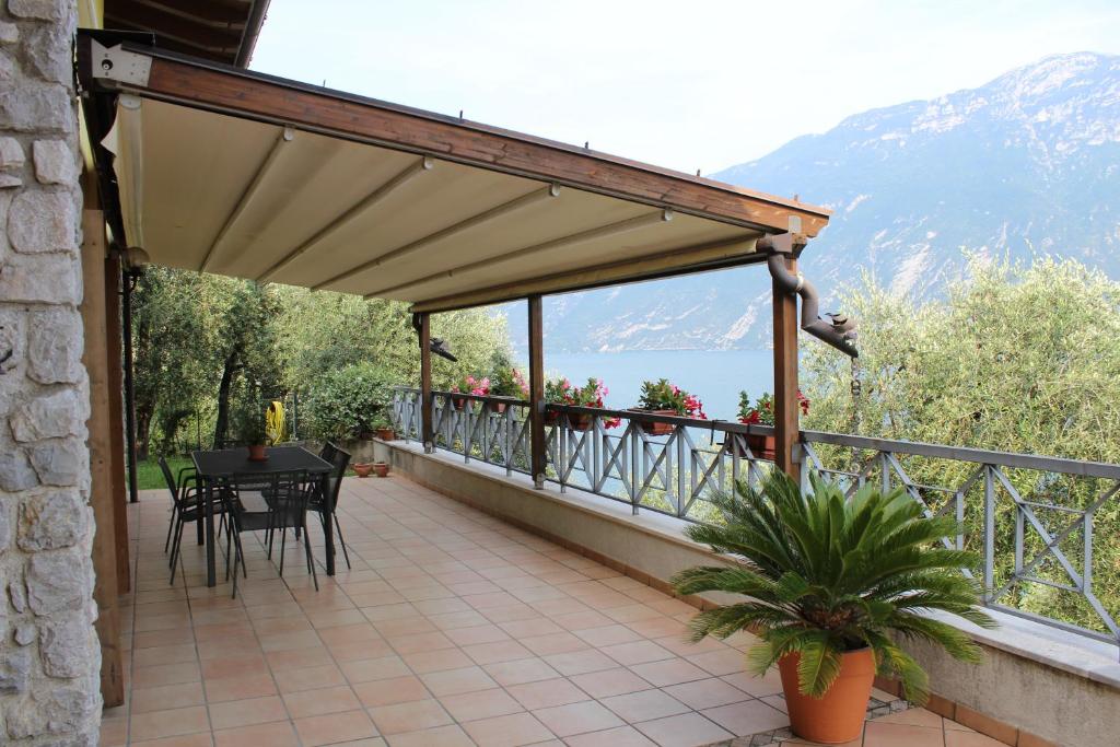 a balcony of a house with a table and chairs at La Casa sul Lago Apartments - Olive Tree Apartment in Limone sul Garda