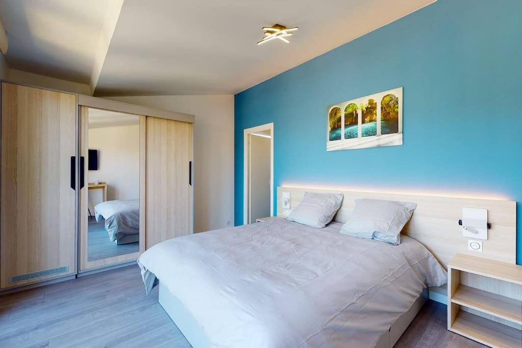 ein Schlafzimmer mit einem großen Bett mit blauer Wand in der Unterkunft 06.Studio#Creteil#Loft#Cinéma#Exclusif in Créteil
