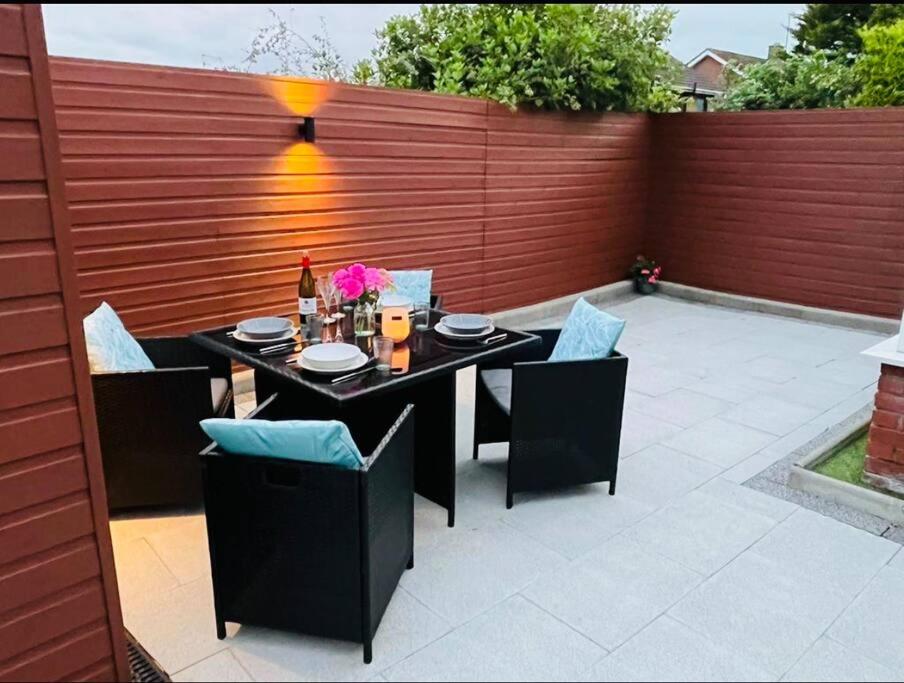 d'une terrasse avec une table, des chaises et une clôture. dans l'établissement The Bay house, à Derry Londonderry