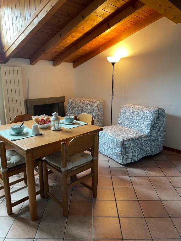 un soggiorno con tavolo in legno e divano di La Casa Rustica Di Ale E Becky a Bergamo