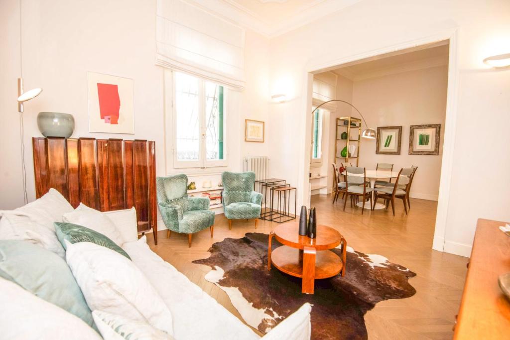 ein Wohnzimmer mit einem weißen Sofa und einem Tisch in der Unterkunft Raffaello Apartment by Firenze Prestige in Florenz