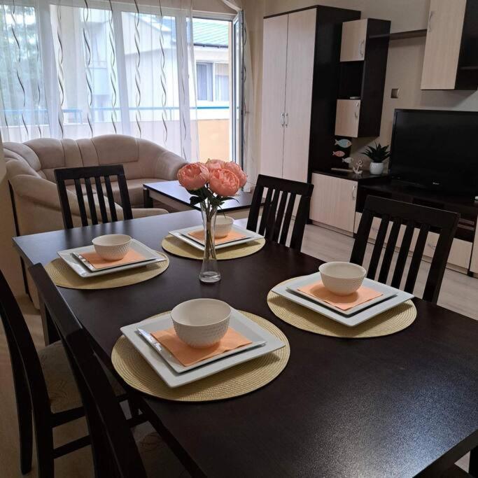 a dining room table with plates and bowls on it at Apartment RELAX in the city center, free parking in Yambol