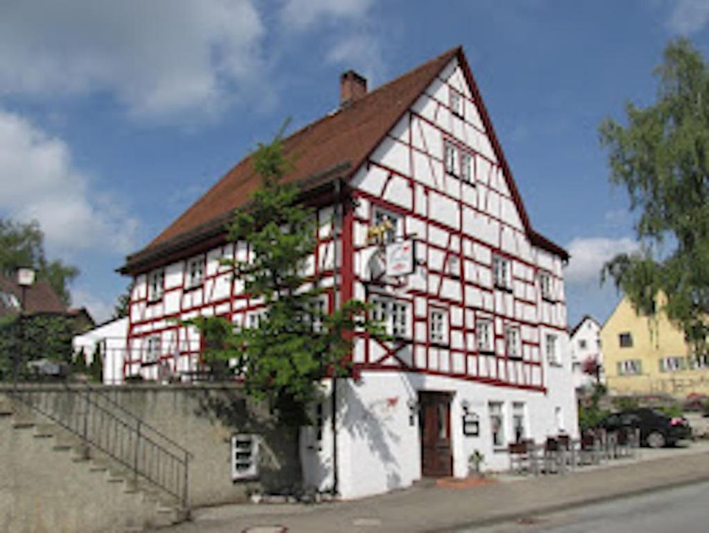 a large red and white building with a brown roof at Schildwirtschaft Zum Rothen Ochsen in Laupheim
