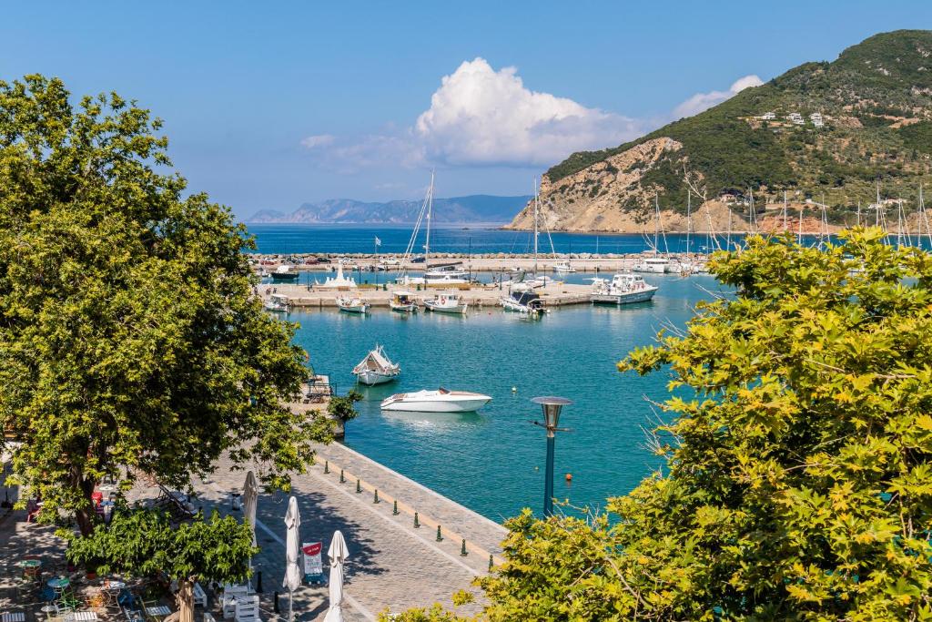 un puerto deportivo con barcos en el agua y árboles en Sentefi Maisonette, en Skopelos Town
