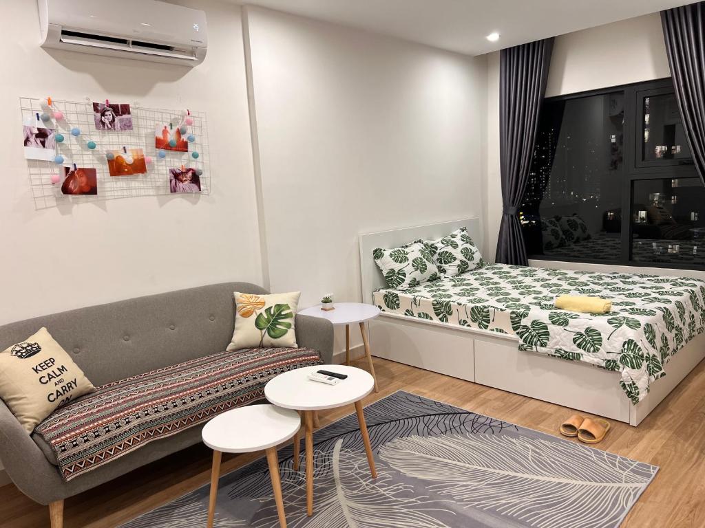 Vinhome Grand Park Homestay House-Romantic Stay في Gò Công: غرفة معيشة صغيرة مع أريكة ونافذة