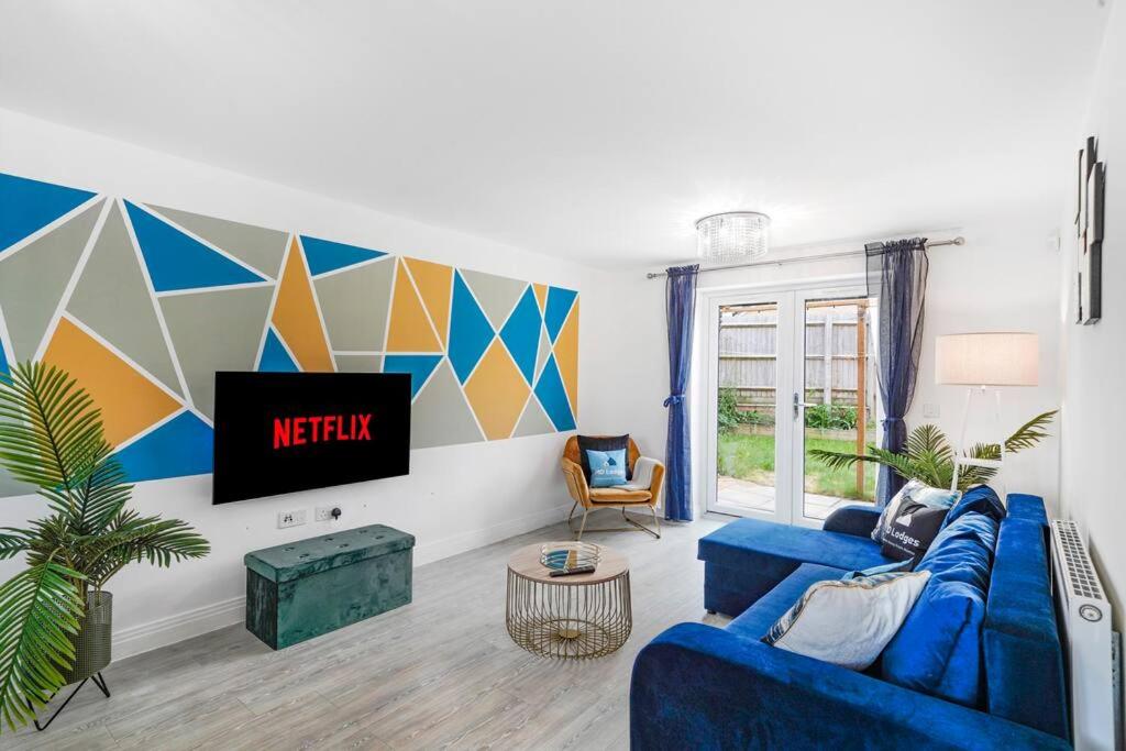彼得伯勒的住宿－7 bed, 5 bedroom, Contractors, Peterborough area，客厅配有蓝色的沙发和电视
