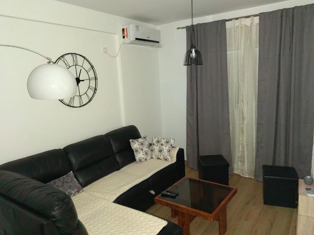 uma sala de estar com um sofá de couro preto e uma mesa em Stan na dan Niksic em Nikšić