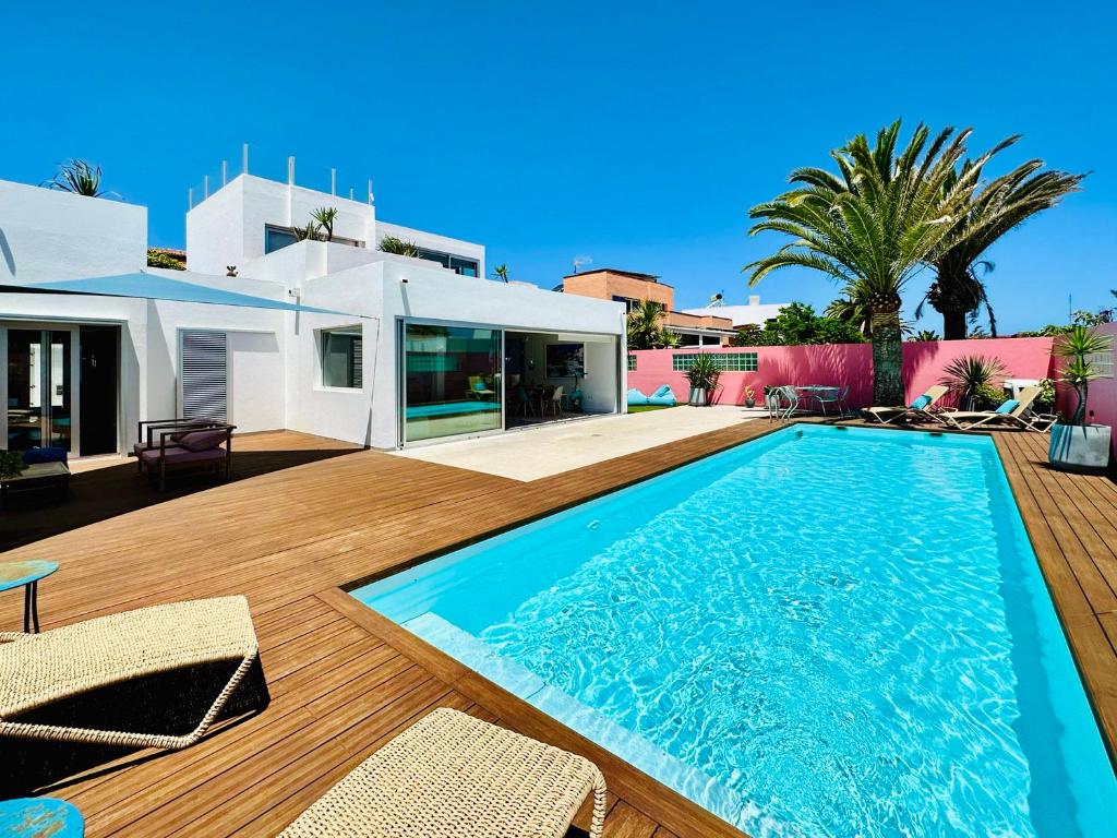 une villa avec piscine et une maison dans l'établissement Casa Color, à Corralejo