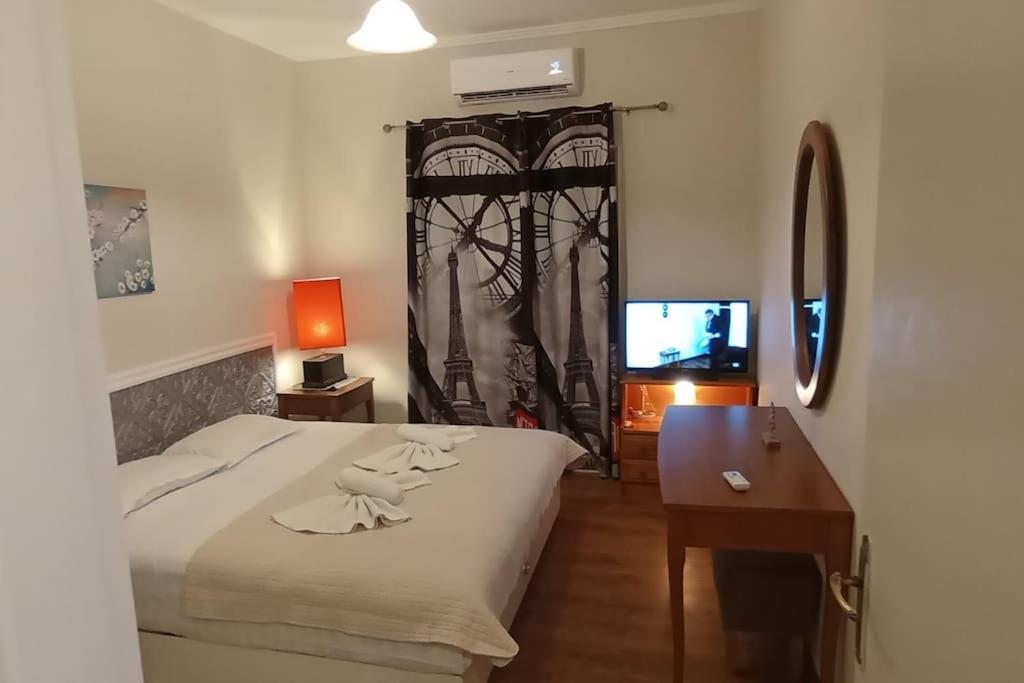 una camera da letto con un letto, una scrivania e una televisione di Ipsos Apartment Mari a Città di Corfù