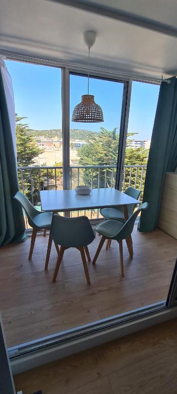 une salle à manger avec une table et des chaises sur un balcon dans l'établissement Joli studio vue Mont Saint Clair, parking, ménage et linge de lit inclus, à Sète