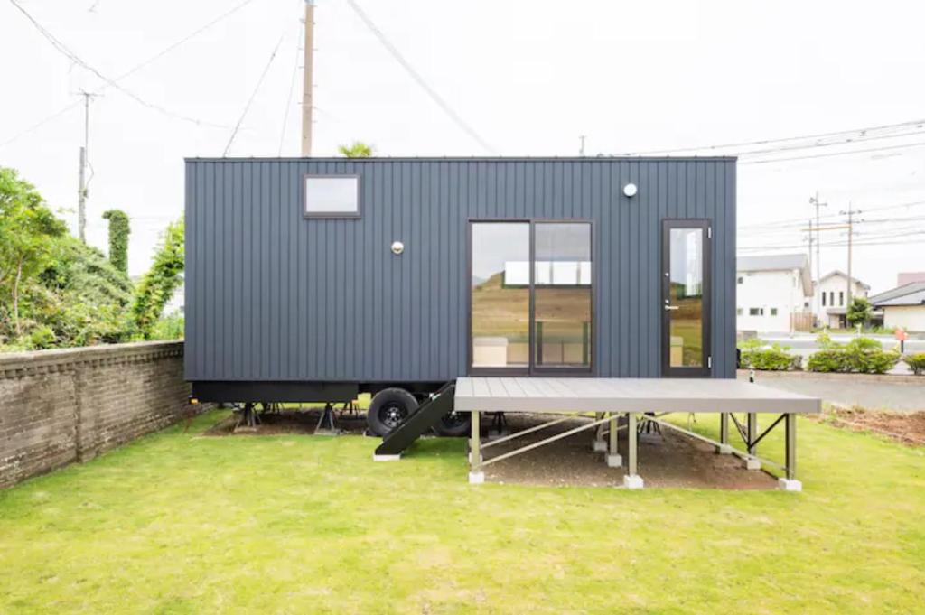 een klein huisje bovenop een grasveld bij FUKUOKA FUKUTSU MUNAKATA YUSUKE HOUSE in Kōnominato