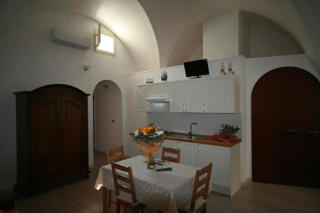 a kitchen with a table with a vase of flowers on it at Santa Maria de Lu Trisciulu in Castrignano del Capo
