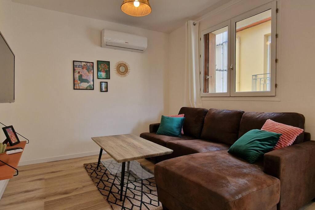 a living room with a brown couch and a table at Appartement en bord de mer 2 in Banyuls-sur-Mer