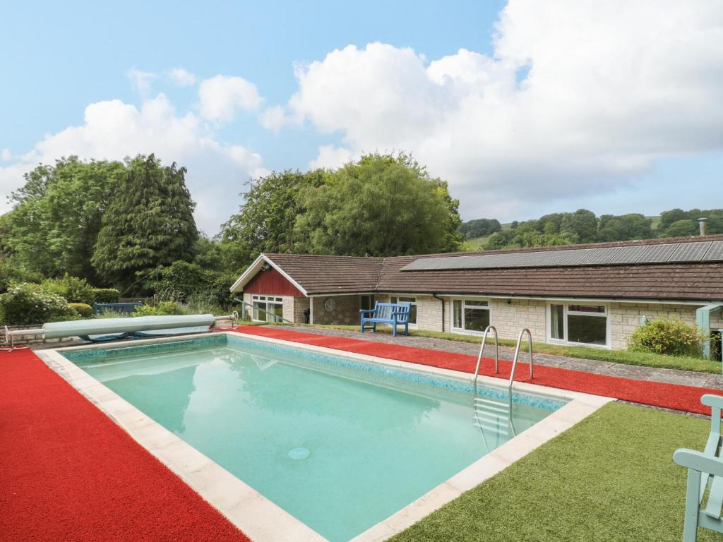 a swimming pool in front of a house at Deepdene in Dorchester