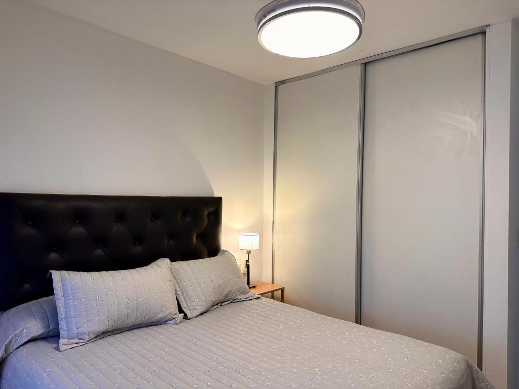 a bedroom with a bed with a black headboard at Modern&Nordic Apartament Lomitas (2 ambientes) in Lomas de Zamora
