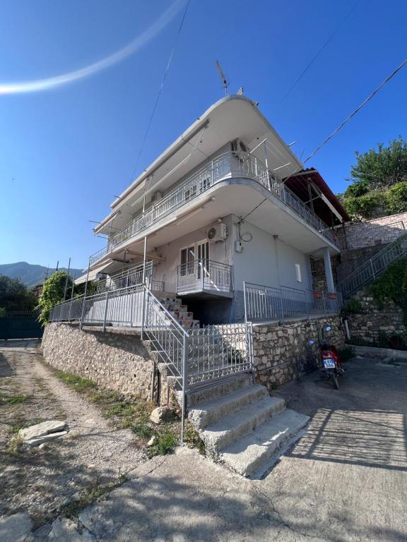 un edificio blanco con escaleras delante en Dhoma Plazhi Husi en Himare