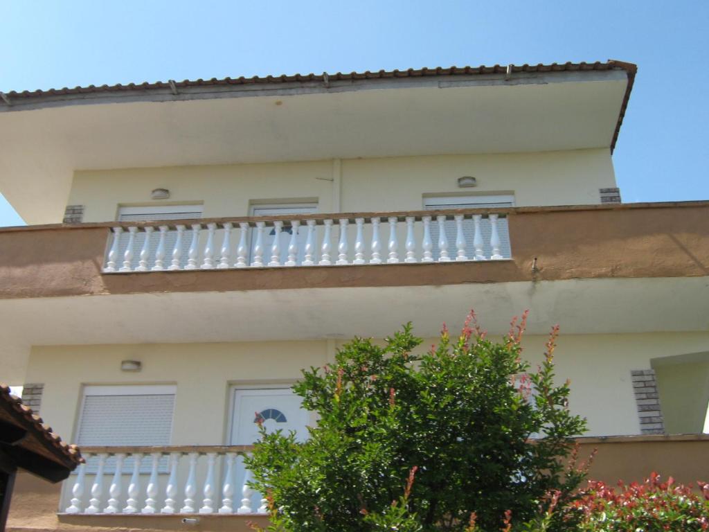 a building with white balconies on the side of it at Εξοχικό με θέα στον Όλυμπο in Skotina
