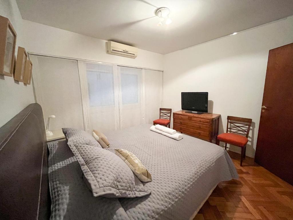 um quarto com uma cama, uma secretária e uma televisão em Coqueto departamento en Recoleta em Buenos Aires