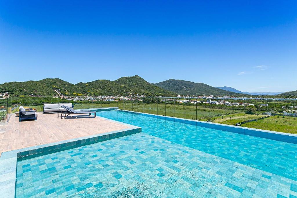 a swimming pool with a view of the mountains at OKA FLORIPA in Florianópolis