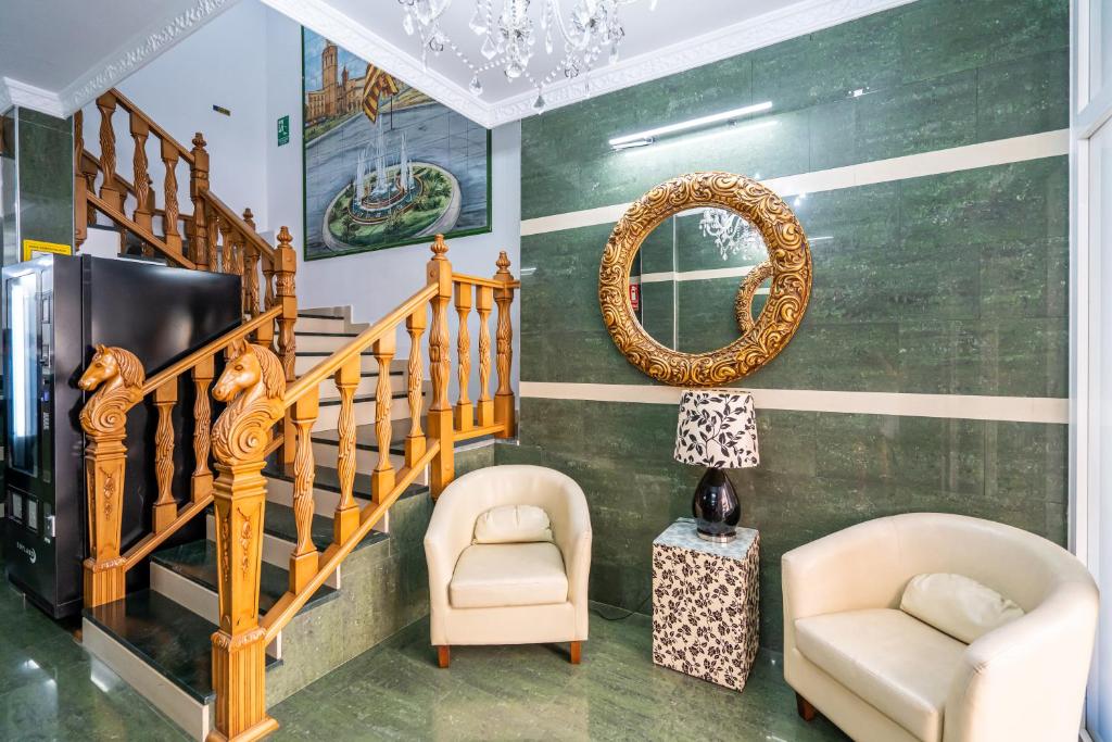 ein Wohnzimmer mit einer Treppe, 2 Stühlen und einem Spiegel in der Unterkunft Hostal RR Feria by Beleret in Valencia