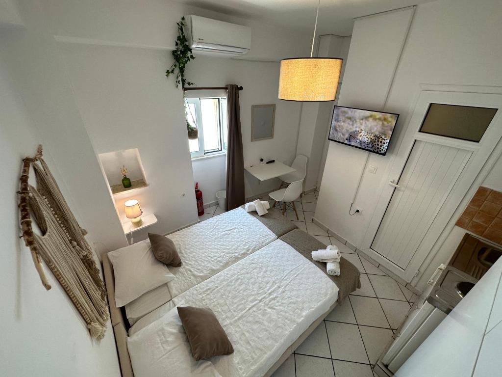 a small white bedroom with a bed and a sink at Valente Rooms Kythira in Kythira