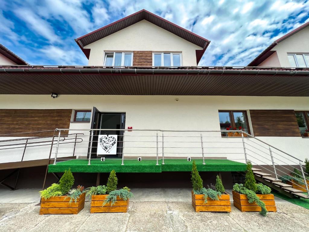a house with potted plants in front of it at Pod Gromadzyniem Resort in Ustrzyki Dolne
