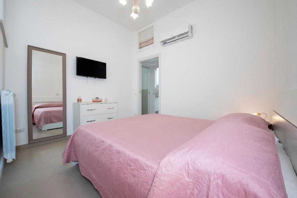 ein Schlafzimmer mit einem rosa Bett und einem Spiegel in der Unterkunft LA CASETTA DEI RICORDI in Agerola