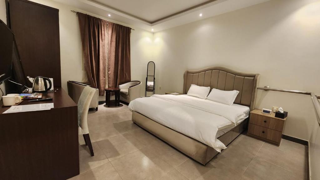 Pokój hotelowy z łóżkiem, biurkiem i biurkiem w obiekcie تــرامونتــان w mieście Ha'il