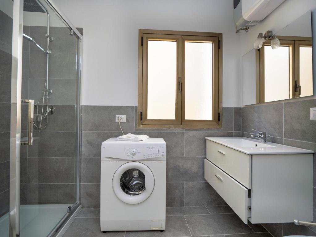 W łazience znajduje się pralka i umywalka. w obiekcie Iside Accommodations w mieście Olbia