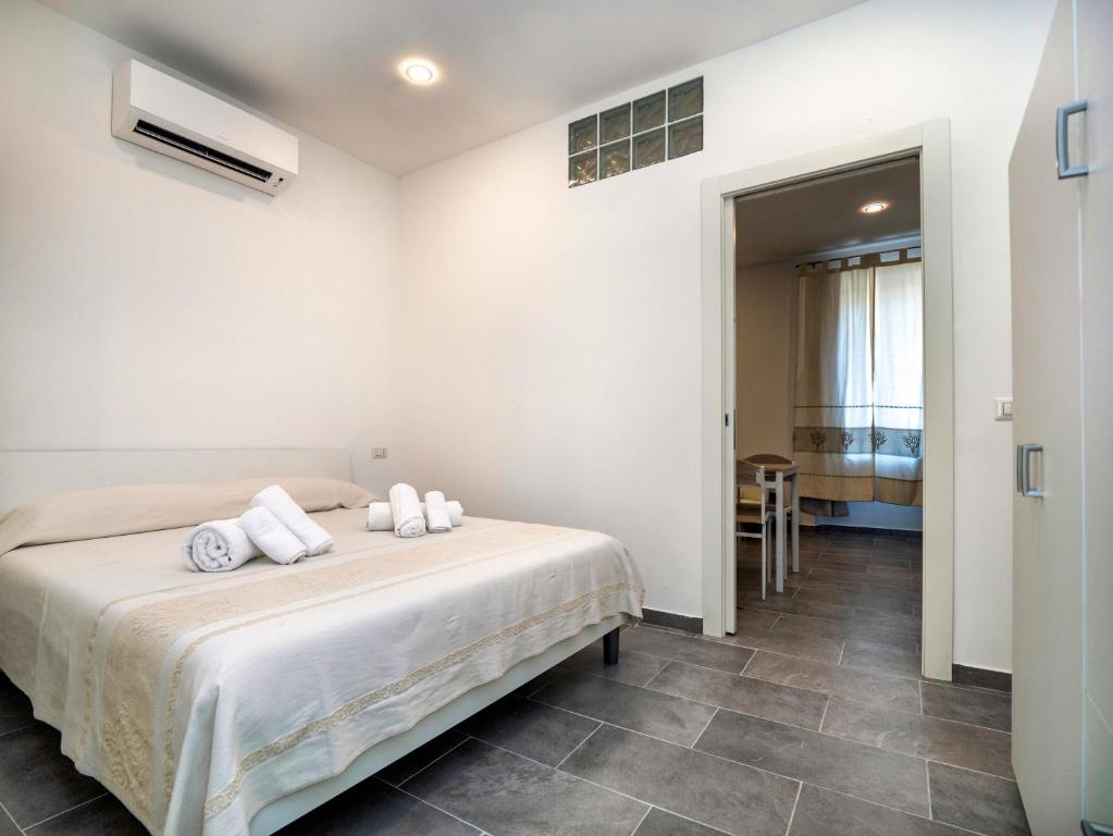 sypialnia z łóżkiem z białą pościelą i ręcznikami w obiekcie Iside Accommodations w mieście Olbia