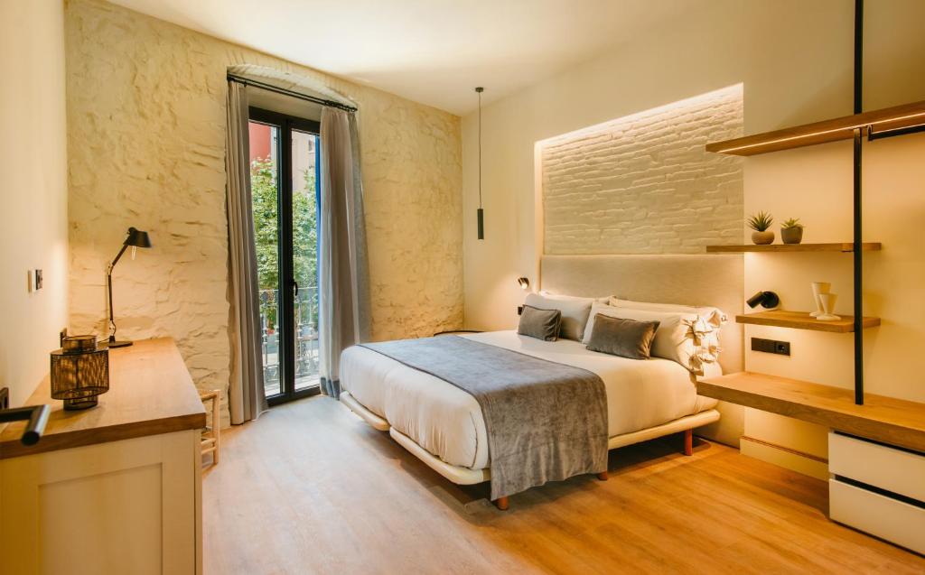 a bedroom with a bed and a large window at Casa Indiana Hotel Boutique in Blanes