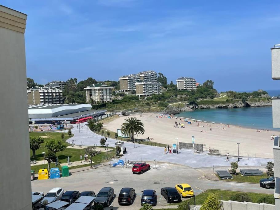 een strand met auto's geparkeerd op een parkeerplaats bij Ostende Beach View apartment in Castro-Urdiales