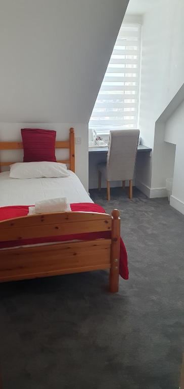 a bedroom with a bed and a desk and a chair at Granite City Guest House in Aberdeen