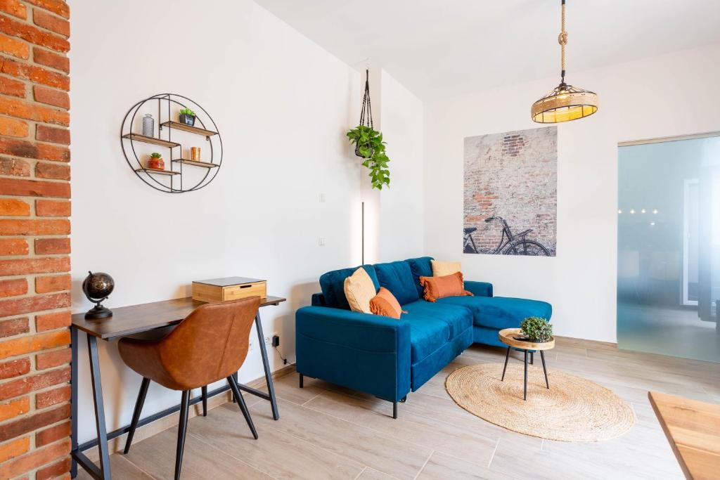 uma sala de estar com um sofá azul e uma mesa em FeelgooD Apartments DELUXE Zwickau CityCenter mit TG-Stellplatz, Netflix und Waipu-TV em Zwickau