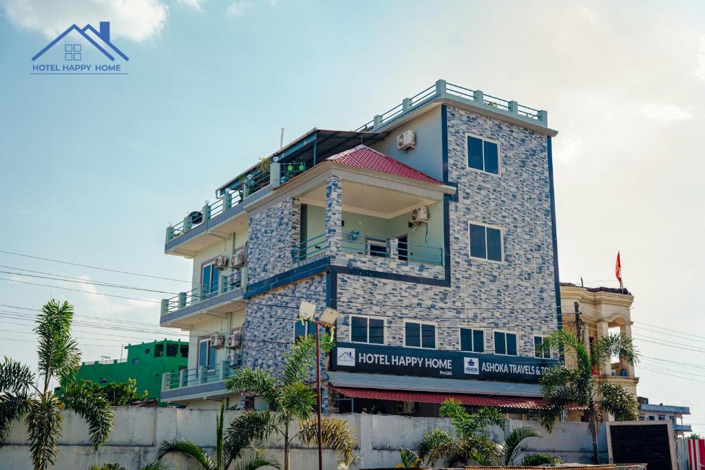 a tall stone building with a sign on it at Hotel Happy Home in Bhairāhawā